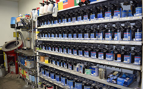 Shelf with 6 rows of truck body repair equipment with water spray bottles on the top.